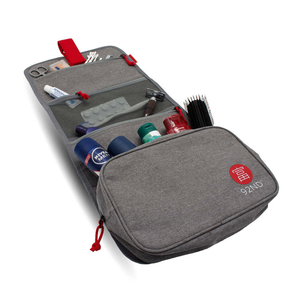 Hanging toiletry bag in grey, filled with products.