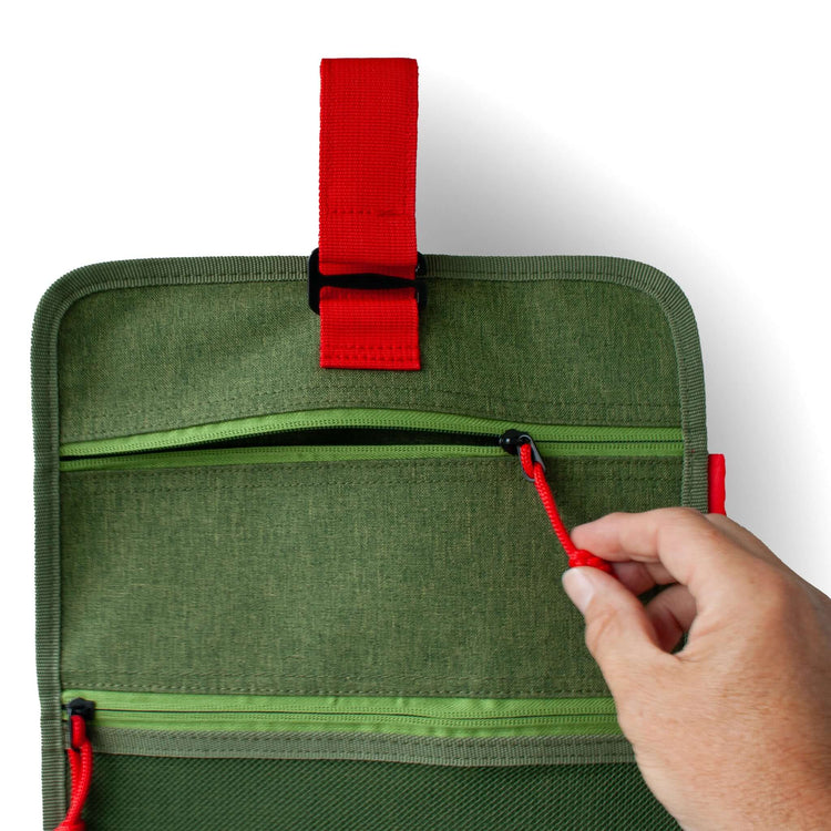 Hanging Toiletry Bag Green – hand opens the zipper of the wash roll